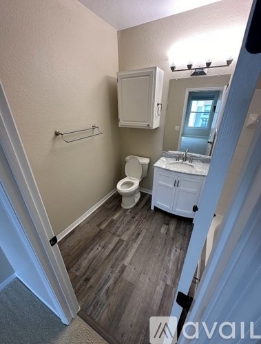 A small bathroom with a toilet, sink, and cabinet.