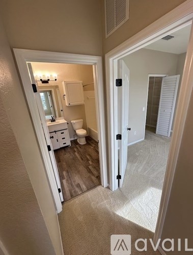 A bathroom with a toilet, sink, and mirror.