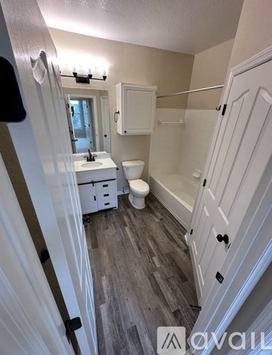 A bathroom with a toilet, sink, and bathtub.