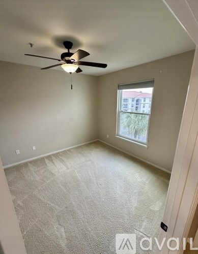A room with a ceiling fan and a window.
