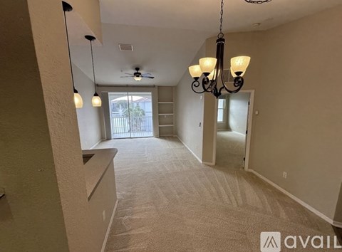 A spacious room with a chandelier and a ceiling fan.