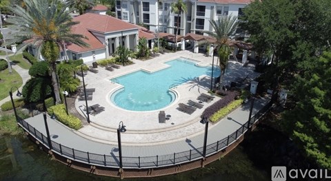 A pool surrounded by a fence and trees.
