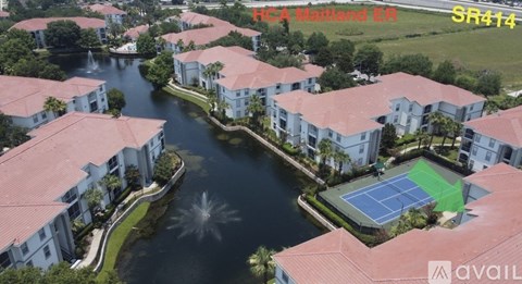 A tennis court is located in the middle of a lake surrounded by buildings.