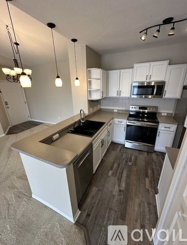 A kitchen with a white island and stainless steel appliances.