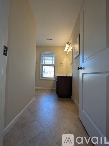 A hallway with a tiled floor and a door on the right.