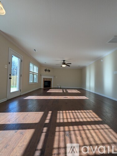 A living room with a fireplace and a ceiling fan.