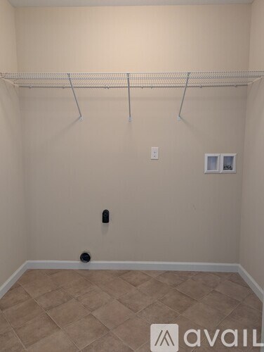 A room with a white wall and a white shelf.