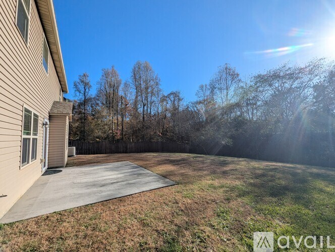 A house with a driveway and trees in the background.