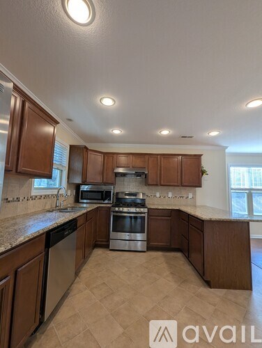 A kitchen with brown cabinets and a tiled floor.