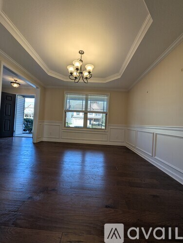 A room with wooden floors and a chandelier.