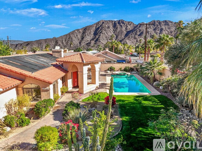 A house with a pool and a mountain in the background.