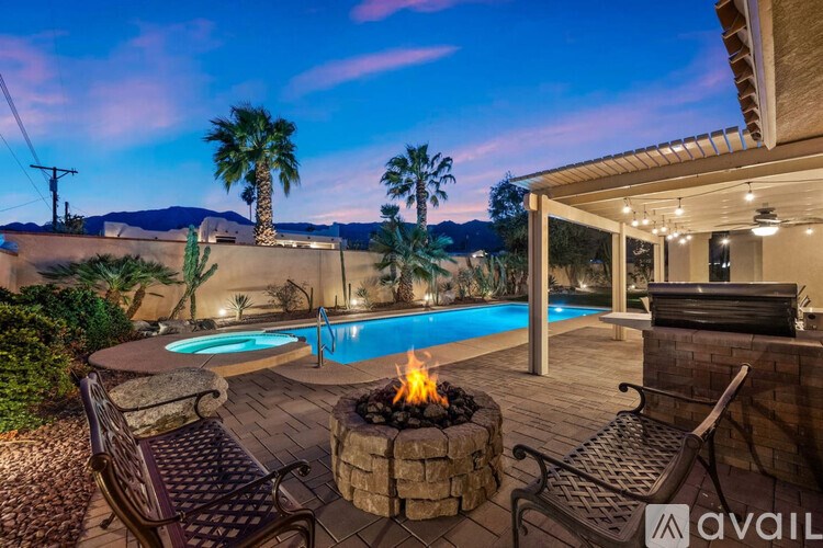 A backyard with a fire pit and patio furniture.