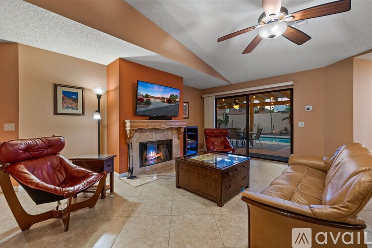 A living room with a fireplace, a chair, a sofa, and a television.