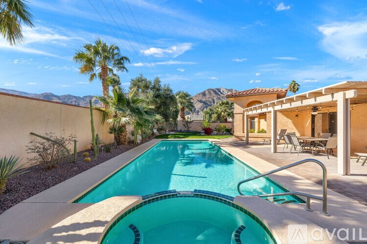 A pool in a desert-like setting with mountains in the background.