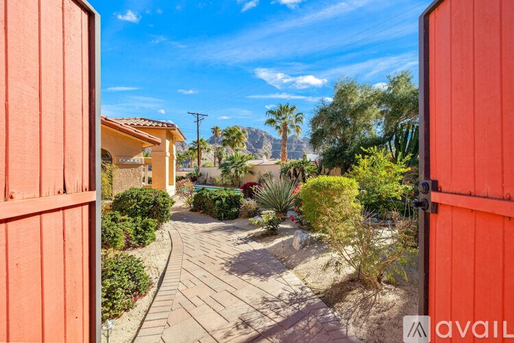 A view from a red gate looking out onto a desert landscape.