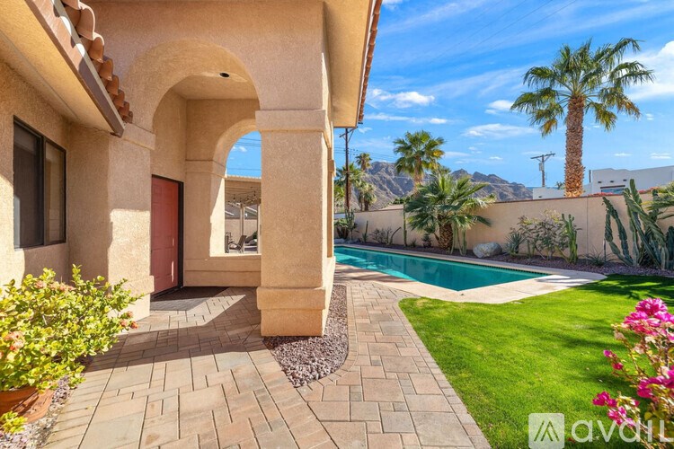 A house with a pool and a palm tree in the background.