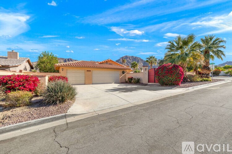 A house with a red roof and a driveway in front of it.