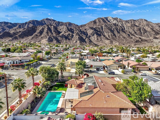 A mountainous landscape with a residential area in the foreground.