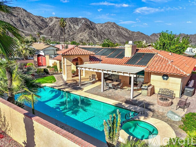 A house with a pool and mountains in the background.