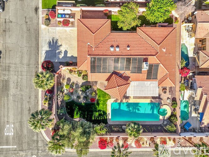 A bird's eye view of a house with a pool and a tennis court.