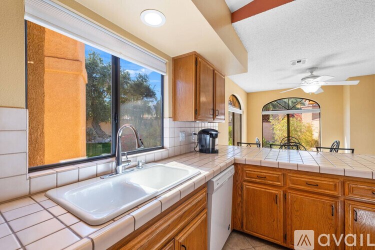 A kitchen with wooden cabinets and a white sink.