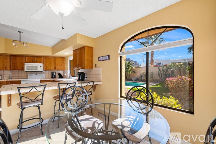 A kitchen with a table and chairs in front of a window.