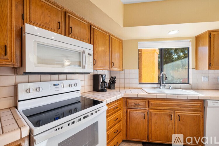A kitchen with wooden cabinets and white appliances.