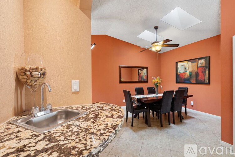 A kitchen with orange walls and a marble countertop.