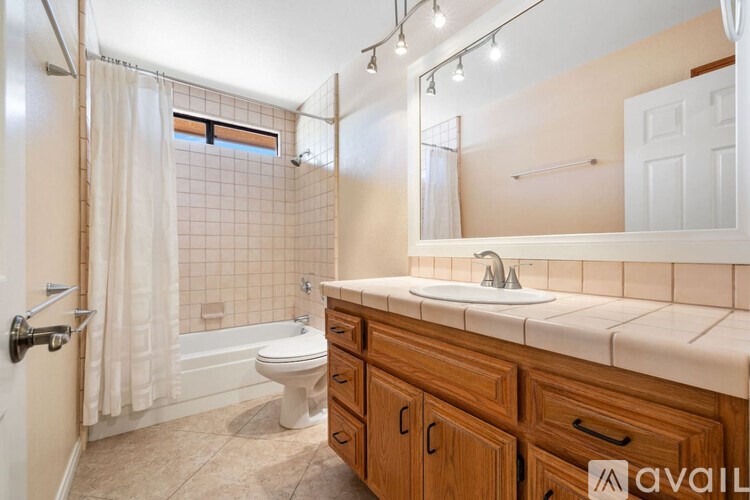 A bathroom with a toilet, sink, and shower.