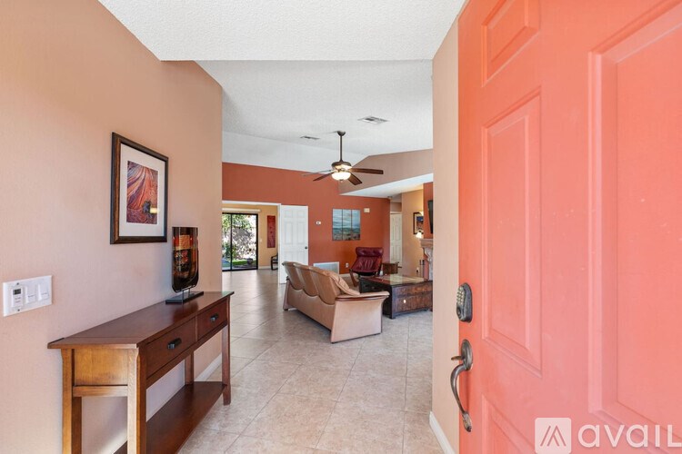 A living room with a brown wooden desk and a painting on the wall.