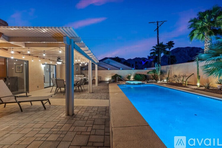A poolside area with a patio and a mountain view.