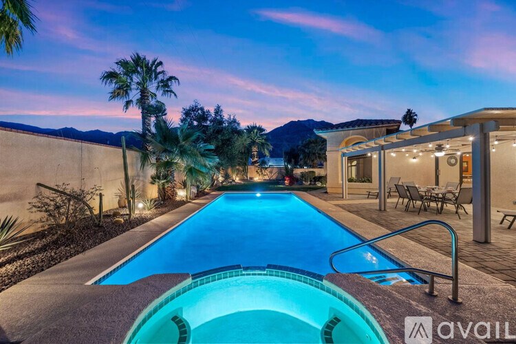 A swimming pool with a slide and a sunset in the background.
