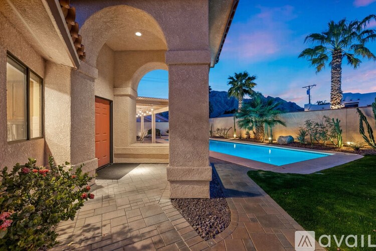 A house with a pool and a palm tree in the background.