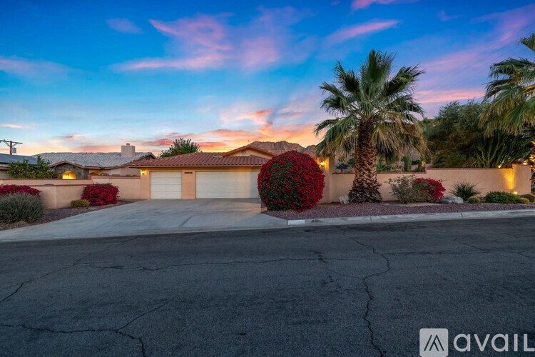 A house with a palm tree in front of it.