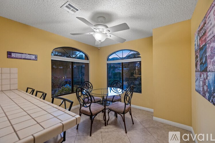 A dining room with a table and chairs.