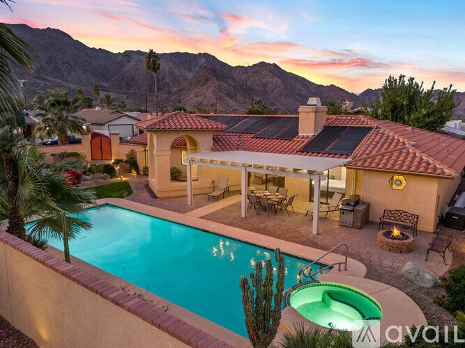 A house with a pool and a cactus in front of it.