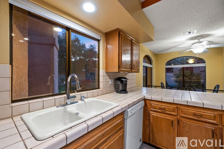 A kitchen with wooden cabinets and a white sink.