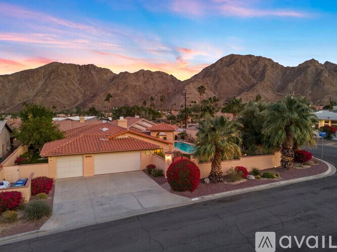 A house with a red roof and a mountain in the background.