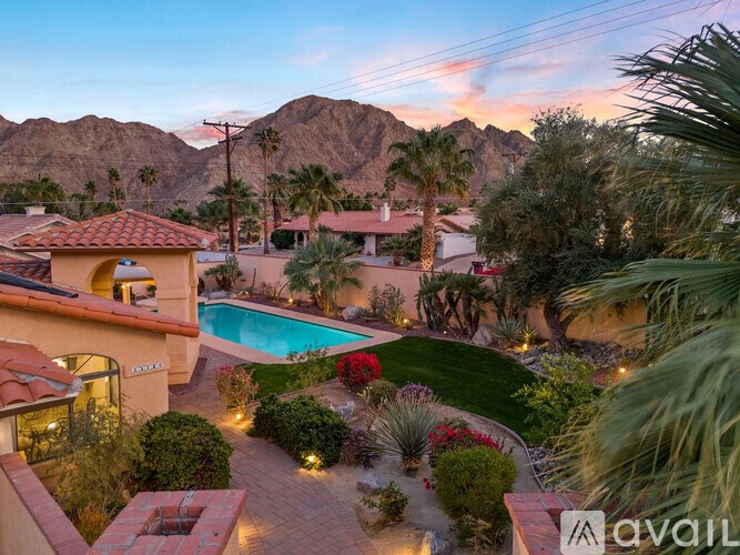 A house with a pool surrounded by a garden.
