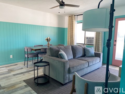 A living room with a grey couch and a ceiling fan.
