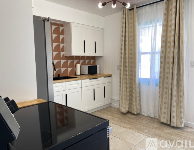 A kitchen with a black countertop and white cabinets.