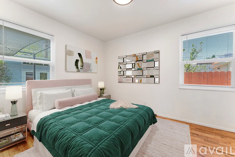 A bedroom with a green bedspread and a pink headboard.