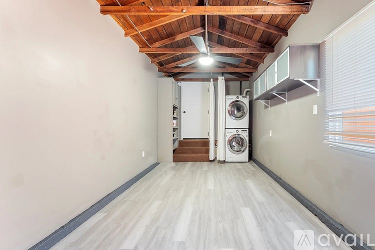 A room with a wooden ceiling and a washing machine.