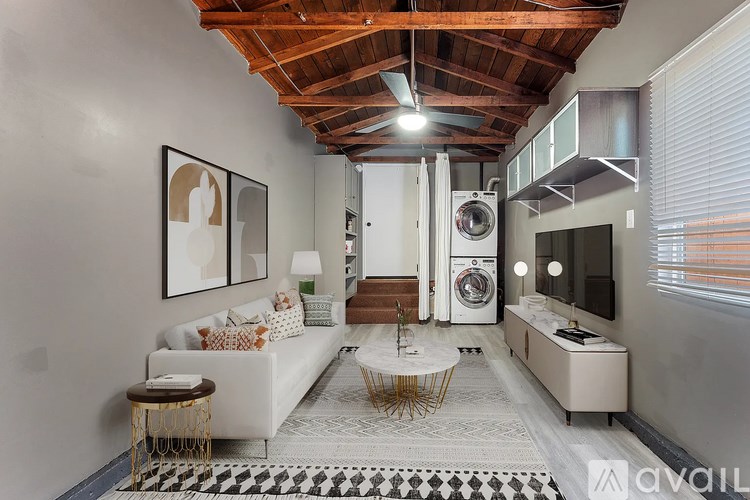 A modern living room with a white sofa and a black and white checkered rug.