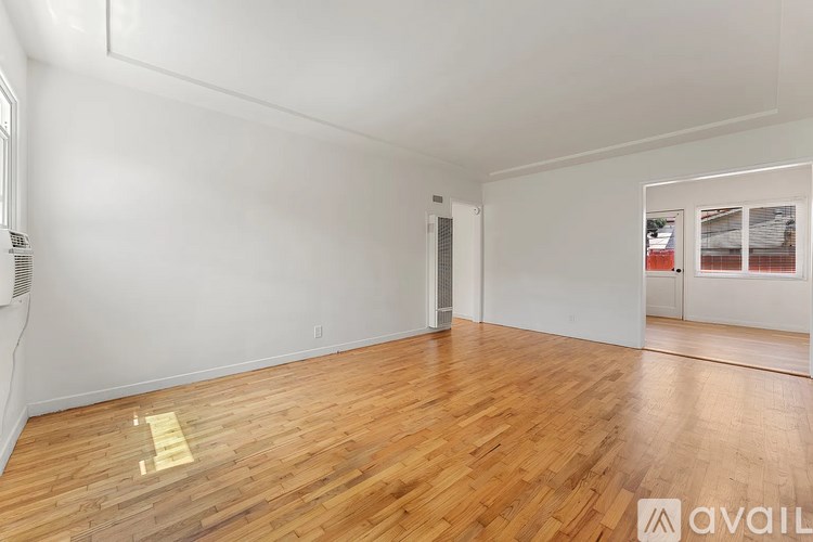 A room with wooden flooring and white walls.