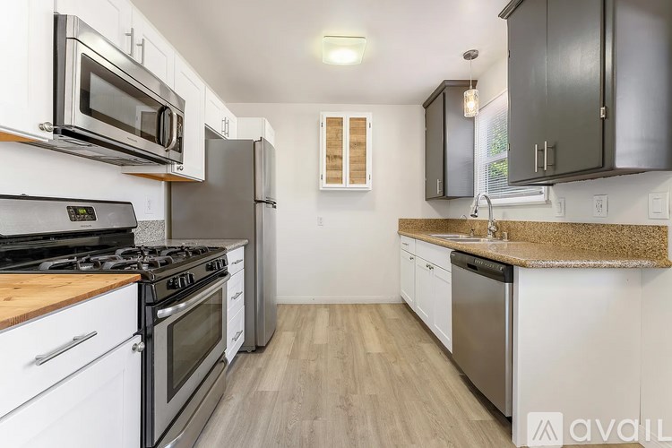 A kitchen with white cabinets and a wooden countertop.