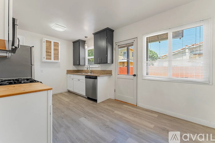 A kitchen with white cabinets and a wooden countertop.