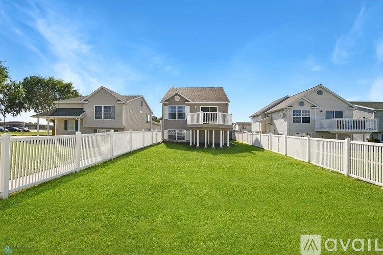 A row of houses with a white picket fence in front.