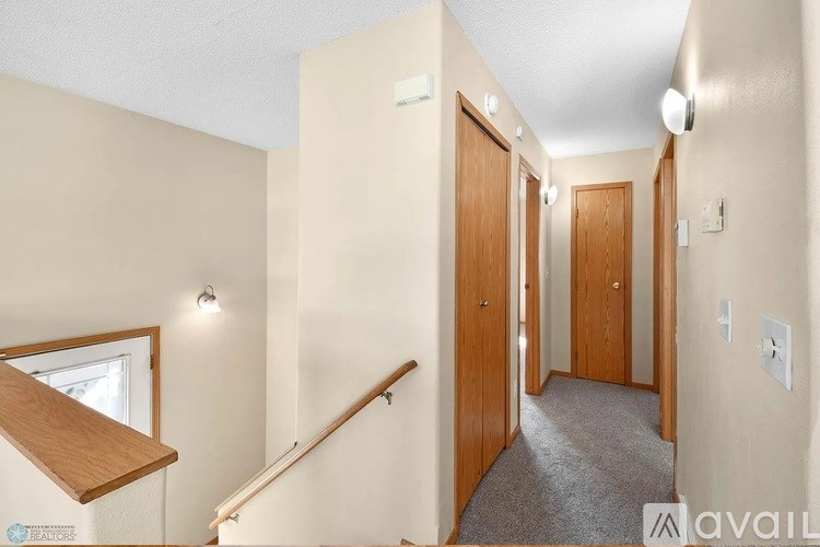 A hallway with a staircase and three doors.