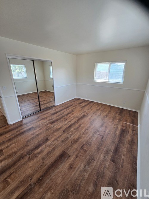 A room with wooden flooring and a window.